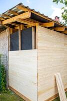 Exterior view of a partially constructed wooden wall with exposed framework and insulation photo