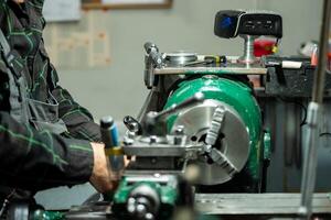 A worker operating a lathe machine, focusing on precise metalworking tasks in a workshop environment. photo