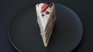 Piece of sweet layer cake with white cream, raspberries and strawberries on a dark concrete background video