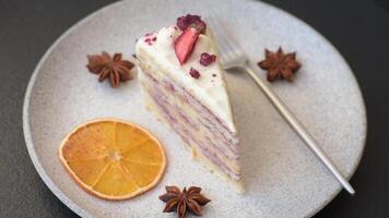 Piece of sweet layer cake with white cream, raspberries and strawberries on a dark concrete background video