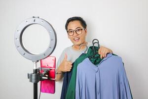 young man selling clothes and accessories online by smartphone live streaming, business online e-commerce isolated backgound photo