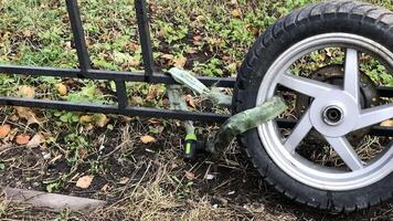 theft of a scooter, only the wheel is left tied with a chain to the fence, camera in motion video