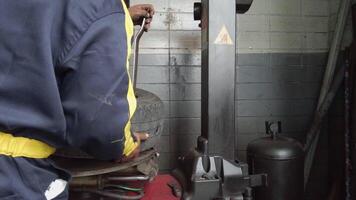 Mechanic changing tire in car service. Tire rotation machine.Car mechanic mounts tire on wheel in a workshop. tire installation in the workshop, video
