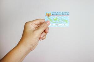 hand holding Indonesian identity cards or E-KTP Kartu Tanda Penduduk owned by Indonesian citizens photo