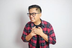 asian man holding hands on chest suffering from heart attack, closeup. photo