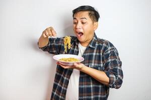 Wow and surprised funny face of Asian man eat instant noodle. photo