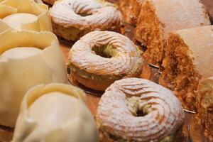 An array of pastries and eclairs are presented in the bakery display case with allure photo