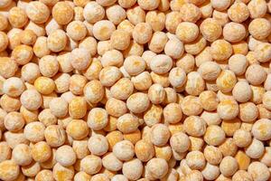 Uncooked Yellow Polished Peas Background. A Culinary Canvas of Dry Yellow Peas, Creating a Lively and Textured Background for Gourmet Cooking. Scattered Raw Polished Peas. Healthy Eating Ingredients photo
