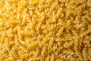 Uncooked Fusilli Pasta. A Culinary Canvas of Spiral Macaroni, Creating a Lively and Textured Background for Gourmet Cooking. Dry Pasta. Raw Macaroni - Top View, Flat Lay photo