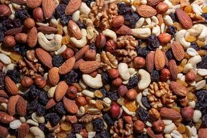 Mixed Nuts. Almonds, Walnuts, Cashews, Peanuts, Hazelnuts, Dried Prunes and Raisins. Different Nut Mix. Background from Various Nuts and Dried Fruits photo