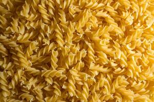 Uncooked Fusilli Pasta. A Culinary Canvas of Spiral Macaroni, Creating a Lively and Textured Background for Gourmet Cooking. Dry Pasta. Raw Macaroni - Top View, Flat Lay photo
