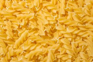 Uncooked Fusilli Pasta. A Culinary Canvas of Spiral Macaroni, Creating a Lively and Textured Background for Gourmet Cooking. Dry Pasta. Raw Macaroni - Top View, Flat Lay photo