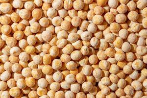 Uncooked Yellow Polished Peas Background. A Culinary Canvas of Dry Yellow Peas, Creating a Lively and Textured Background for Gourmet Cooking. Scattered Raw Polished Peas. Healthy Eating Ingredients photo