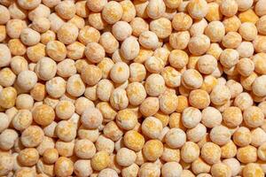 Uncooked Yellow Polished Peas Background. A Culinary Canvas of Dry Yellow Peas, Creating a Lively and Textured Background for Gourmet Cooking. Scattered Raw Polished Peas. Healthy Eating Ingredients photo