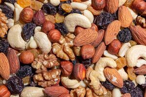 Mixed Nuts. Almonds, Walnuts, Cashews, Peanuts, Hazelnuts, Dried Prunes and Raisins. Different Nut Mix. Background from Various Nuts and Dried Fruits photo