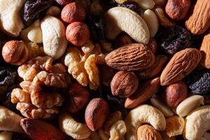 Mixed Nuts. Almonds, Walnuts, Cashews, Peanuts, Hazelnuts, Dried Prunes and Raisins. Different Nut Mix. Background from Various Nuts and Dried Fruits photo