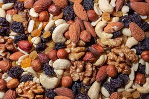 Mixed Nuts. Almonds, Walnuts, Cashews, Peanuts, Hazelnuts, Dried Prunes and Raisins. Different Nut Mix. Background from Various Nuts and Dried Fruits photo