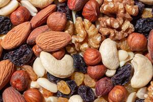 Mixed Nuts. Almonds, Walnuts, Cashews, Peanuts, Hazelnuts, Dried Prunes and Raisins. Different Nut Mix. Background from Various Nuts and Dried Fruits photo