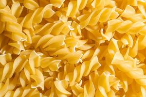 Uncooked Fusilli Pasta. A Culinary Canvas of Spiral Macaroni, Creating a Lively and Textured Background for Gourmet Cooking. Dry Pasta. Raw Macaroni - Top View, Flat Lay photo