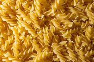 Uncooked Fusilli Pasta. A Culinary Canvas of Spiral Macaroni, Creating a Lively and Textured Background for Gourmet Cooking. Dry Pasta. Raw Macaroni - Top View, Flat Lay photo