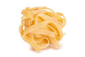 One Classic Italian Raw Egg Fettuccine - Isolated on White Background. Dry Twisted Uncooked Pasta. Italian Culture and Cuisine. Raw Golden Macaroni Pattern - Isolation photo