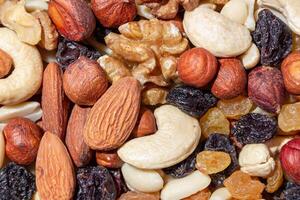 Mixed Nuts. Almonds, Walnuts, Cashews, Peanuts, Hazelnuts, Dried Prunes and Raisins. Different Nut Mix. Background from Various Nuts and Dried Fruits photo