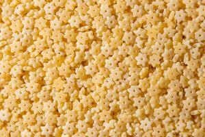 Uncooked Stelline Pasta. A Culinary Canvas of Stelline Macaroni, Creating a Lively and Textured Background for Gourmet Cooking. Dry Pasta. Raw Macaroni - Top View, Flat Lay photo