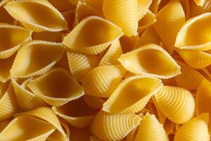Uncooked Conchiglie Pasta. A Culinary Canvas of Conchiglie Macaroni, Creating a Lively and Textured Background for Gourmet Cooking. Dry Pasta. Raw Macaroni - Top View, Flat Lay photo