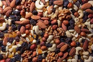 Mixed Nuts. Almonds, Walnuts, Cashews, Peanuts, Hazelnuts, Dried Prunes and Raisins. Different Nut Mix. Background from Various Nuts and Dried Fruits photo