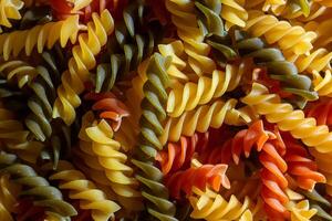 Uncooked Vibrant Colored Fusilli Pasta. A Mesmerizing Culinary Canvas of Multicolored Spirals, Creating a Lively and Textured Background for Gourmet Cooking. Colored Dry Pasta. Raw Macaroni photo