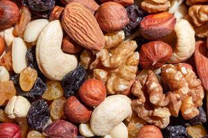 Mixed Nuts. Almonds, Walnuts, Cashews, Peanuts, Hazelnuts, Dried Prunes and Raisins. Different Nut Mix. Background from Various Nuts and Dried Fruits photo