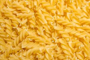 Uncooked Fusilli Pasta. A Culinary Canvas of Spiral Macaroni, Creating a Lively and Textured Background for Gourmet Cooking. Dry Pasta. Raw Macaroni - Top View, Flat Lay photo