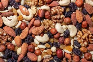 Mixed Nuts. Almonds, Walnuts, Cashews, Peanuts, Hazelnuts, Dried Prunes and Raisins. Different Nut Mix. Background from Various Nuts and Dried Fruits photo