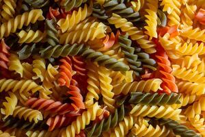 Uncooked Vibrant Colored Fusilli Pasta. A Mesmerizing Culinary Canvas of Multicolored Spirals, Creating a Lively and Textured Background for Gourmet Cooking. Colored Dry Pasta. Raw Macaroni photo