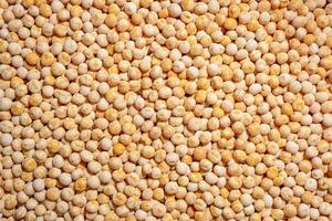 Uncooked Yellow Polished Peas Background. A Culinary Canvas of Dry Yellow Peas, Creating a Lively and Textured Background for Gourmet Cooking. Scattered Raw Polished Peas. Healthy Eating Ingredients photo