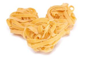 Three Classic Italian Raw Egg Fettuccine - Isolated on White Background. Dry Twisted Uncooked Pasta. Italian Culture and Cuisine. Raw Golden Macaroni Pattern - Isolation photo