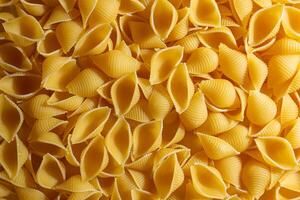 Uncooked Conchiglie Pasta. A Culinary Canvas of Conchiglie Macaroni, Creating a Lively and Textured Background for Gourmet Cooking. Dry Pasta. Raw Macaroni - Top View, Flat Lay photo