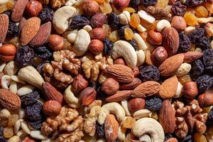 Mixed Nuts. Almonds, Walnuts, Cashews, Peanuts, Hazelnuts, Dried Prunes and Raisins. Different Nut Mix. Background from Various Nuts and Dried Fruits photo