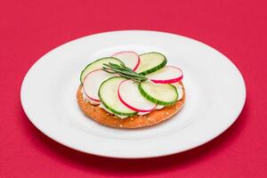 Crispy Cracker Sandwich with Cream Cheese, Fresh Cucumber and Radish on White Plate photo