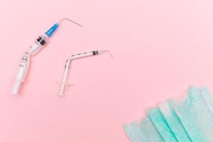 Anti Vaccine Movement and Anti Mask Concept - Broken Medical Syringe and Green Torn Medical Face Mask on the Pink Background. Pandemic and Lockdown End - Top View, Flat Lay photo