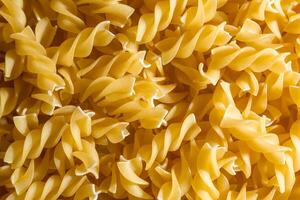 Uncooked Fusilli Pasta. A Culinary Canvas of Spiral Macaroni, Creating a Lively and Textured Background for Gourmet Cooking. Dry Pasta. Raw Macaroni - Top View, Flat Lay photo