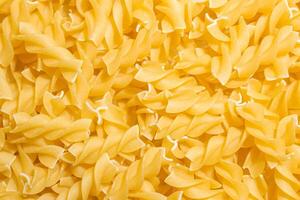 Uncooked Fusilli Pasta. A Culinary Canvas of Spiral Macaroni, Creating a Lively and Textured Background for Gourmet Cooking. Dry Pasta. Raw Macaroni - Top View, Flat Lay photo