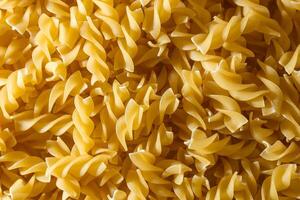 Uncooked Fusilli Pasta. A Culinary Canvas of Spiral Macaroni, Creating a Lively and Textured Background for Gourmet Cooking. Dry Pasta. Raw Macaroni - Top View, Flat Lay photo