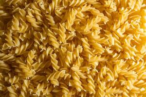 Uncooked Fusilli Pasta. A Culinary Canvas of Spiral Macaroni, Creating a Lively and Textured Background for Gourmet Cooking. Dry Pasta. Raw Macaroni - Top View, Flat Lay photo