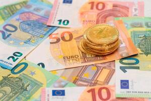 A Stack of Bitcoin Coins on the Euro Banknotes. Money Saving, Cryptocurrency, Blockchain and Anonymous Payments Concept photo