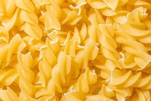 Uncooked Fusilli Pasta. A Culinary Canvas of Spiral Macaroni, Creating a Lively and Textured Background for Gourmet Cooking. Dry Pasta. Raw Macaroni - Top View, Flat Lay photo