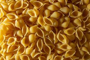Uncooked Conchiglie Pasta. A Culinary Canvas of Conchiglie Macaroni, Creating a Lively and Textured Background for Gourmet Cooking. Dry Pasta. Raw Macaroni - Top View, Flat Lay photo
