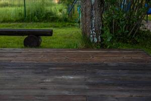 Wooden deck with central sandpit in a backyard setting, surrounded by trees and natural surroundings photo