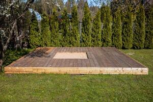 Wooden deck with a central sandpit in a sunny backyard, featuring a clean and simple design photo