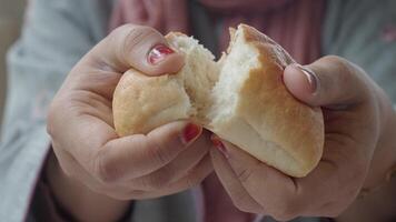 A closeup of hands squeezing a soft, fresh bread roll, emphasizing its texture and taste video